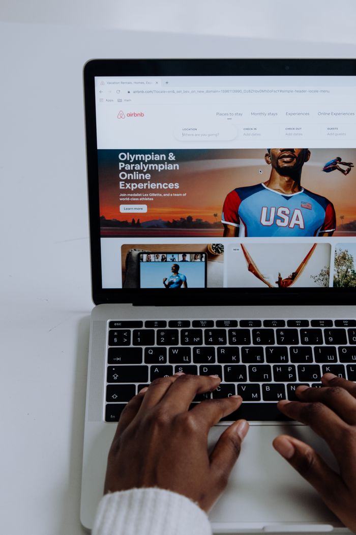 Hands using a laptop to browse online Olympic and Paralympic experiences.
